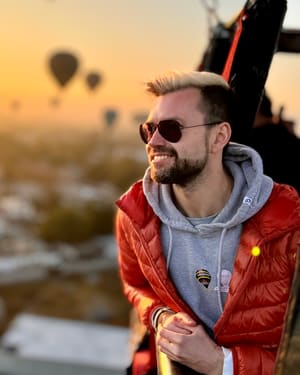 Andrey in a hot air balloon basket at sunrise over the pyramids of Teotihuacán