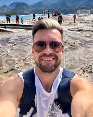 Andrey on the mineral terraces at Hierve el Agua in Oaxaca, mountains in the background