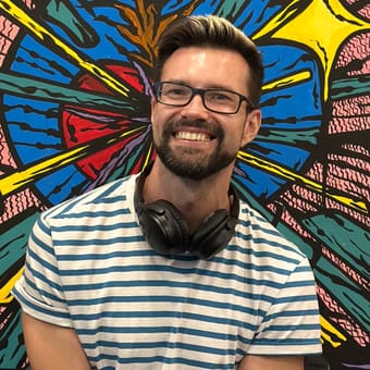 Andrey the Nomad standing in front of a large, brightly painted mural in Mexico City