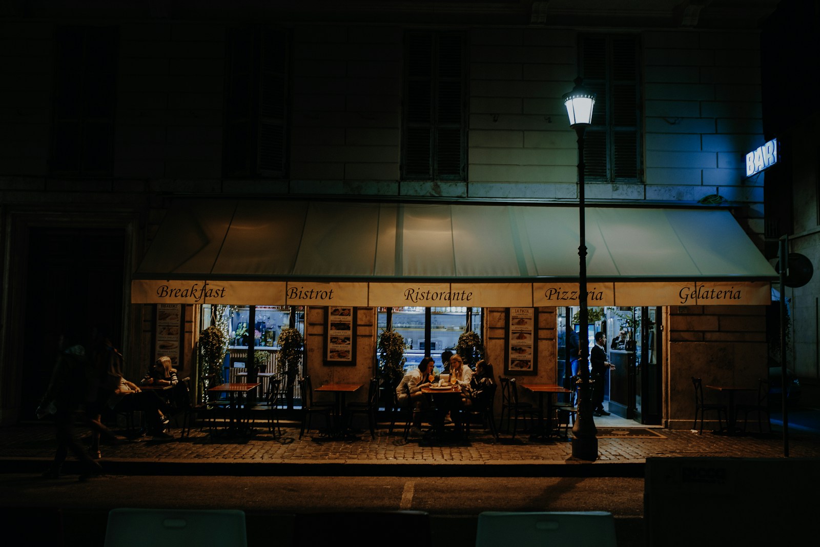 A group of friends sitting around a table outside a building.