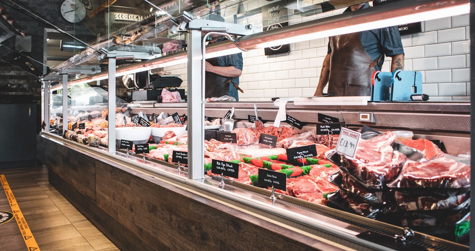 Butcher shop display counter with fresh cuts of meat laid out behind glass.