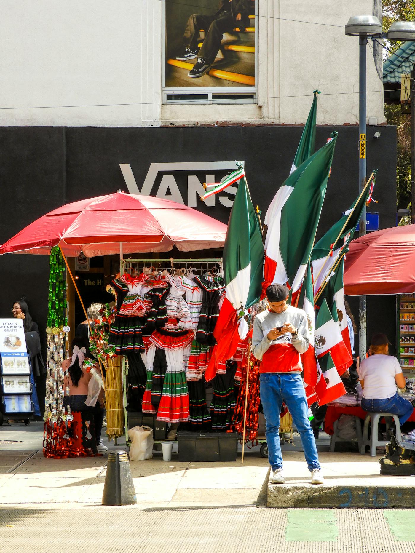 A Mexican flag hanging near market vendors in Mexico City.