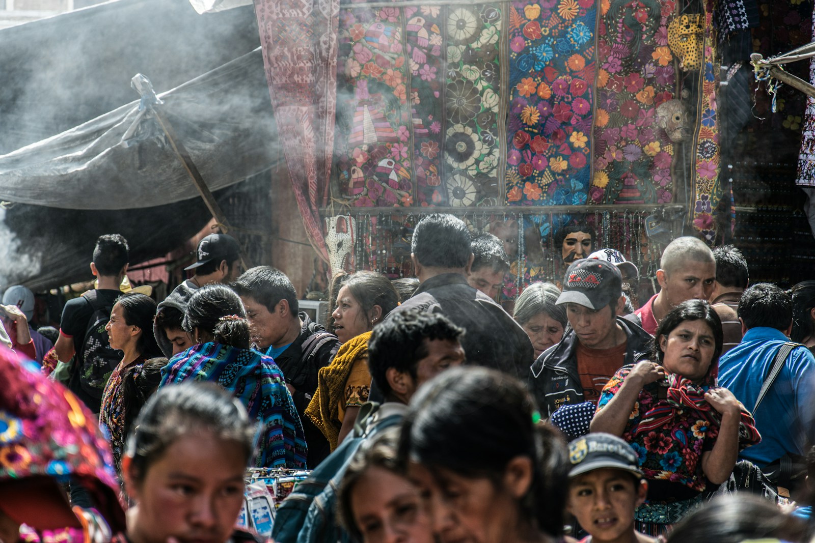 A crowded market aisle with colorful goods on display.