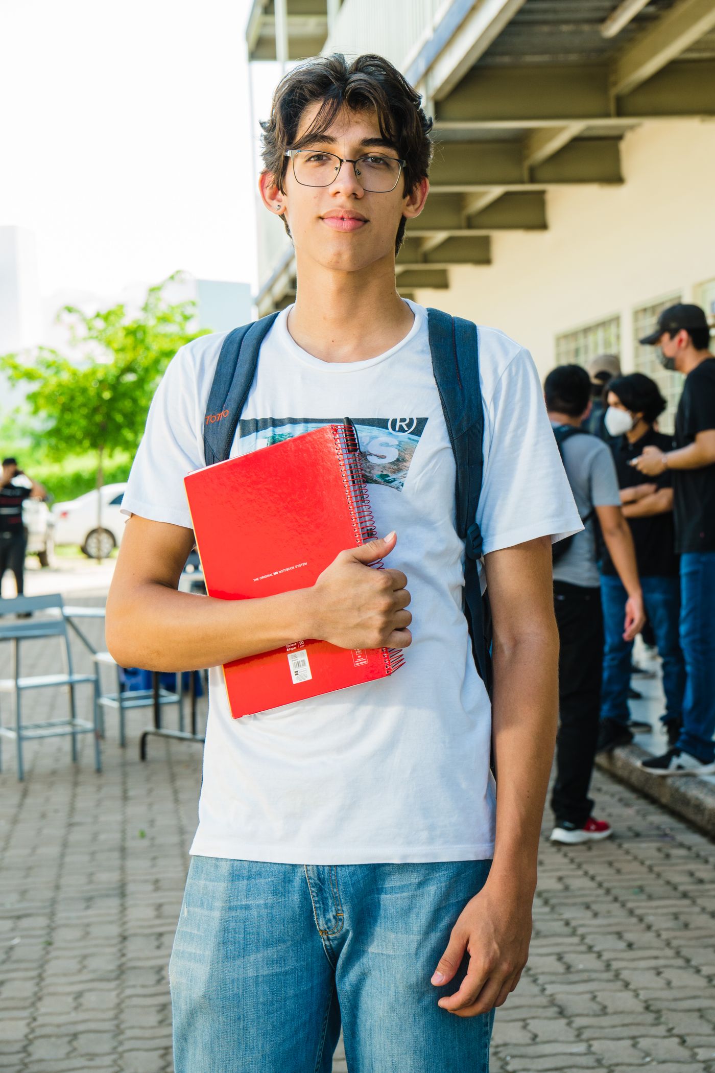 A student writing notes beside school supplies.