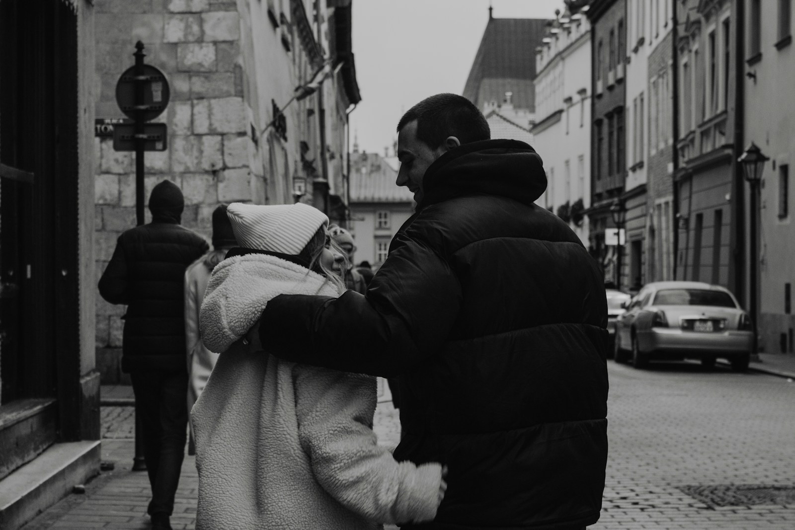 A man and a woman walking together down a city street.