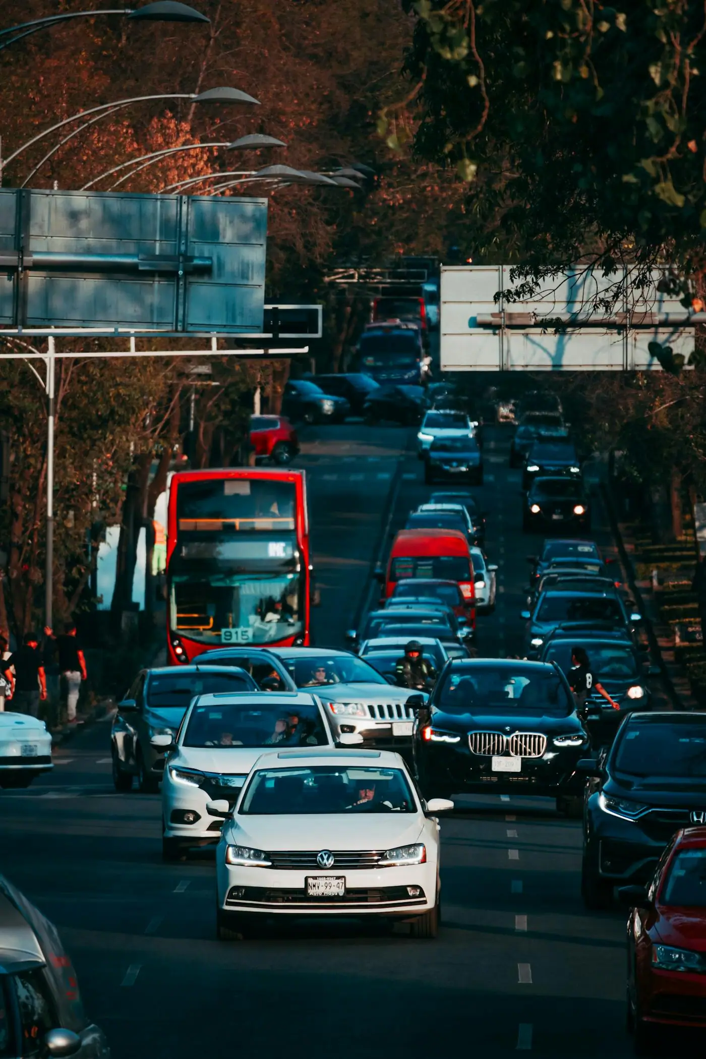 A busy Mexico City street with cars, buses, and pedestrians.