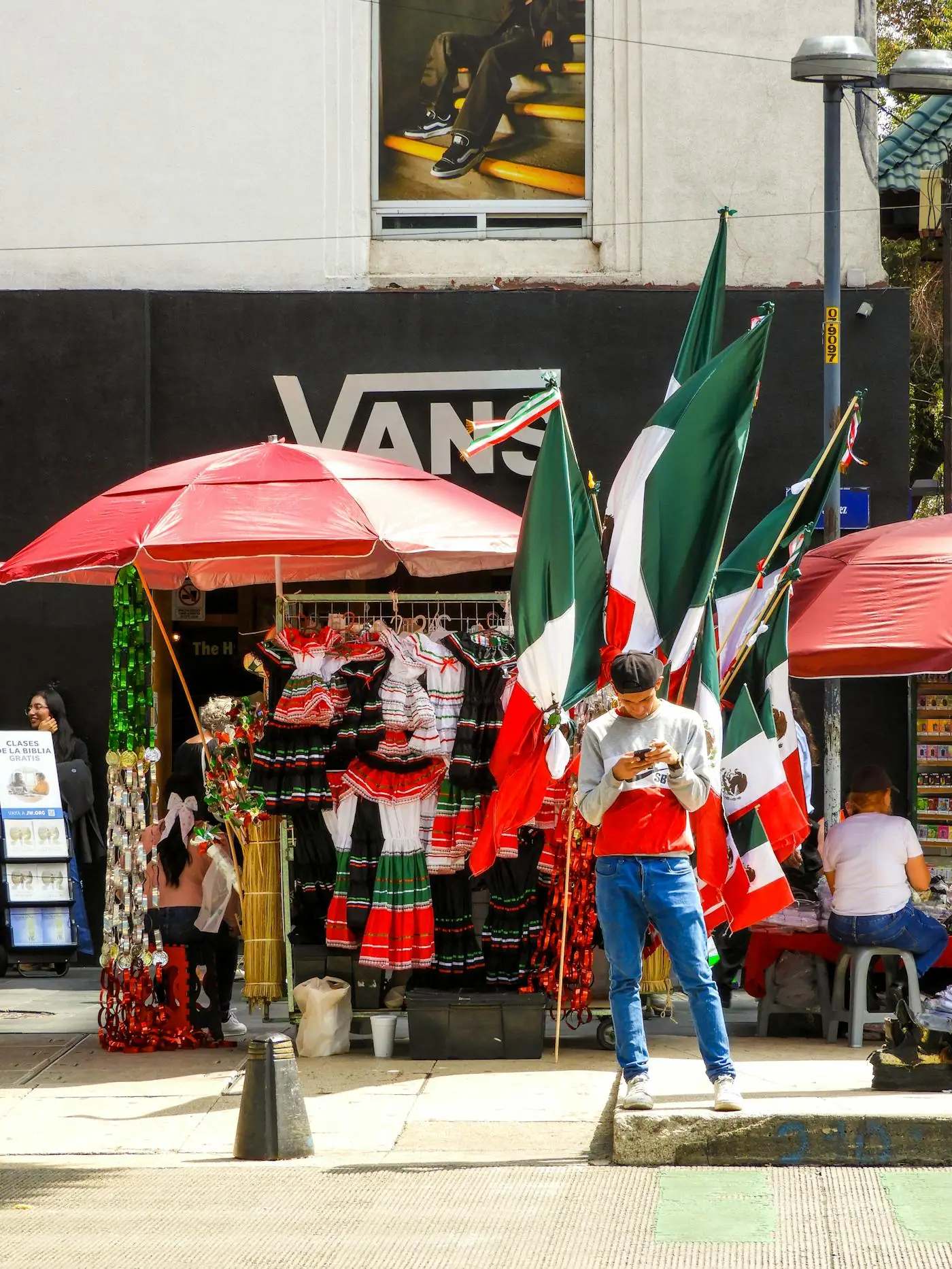 A Mexican flag hanging near market vendors in Mexico City.