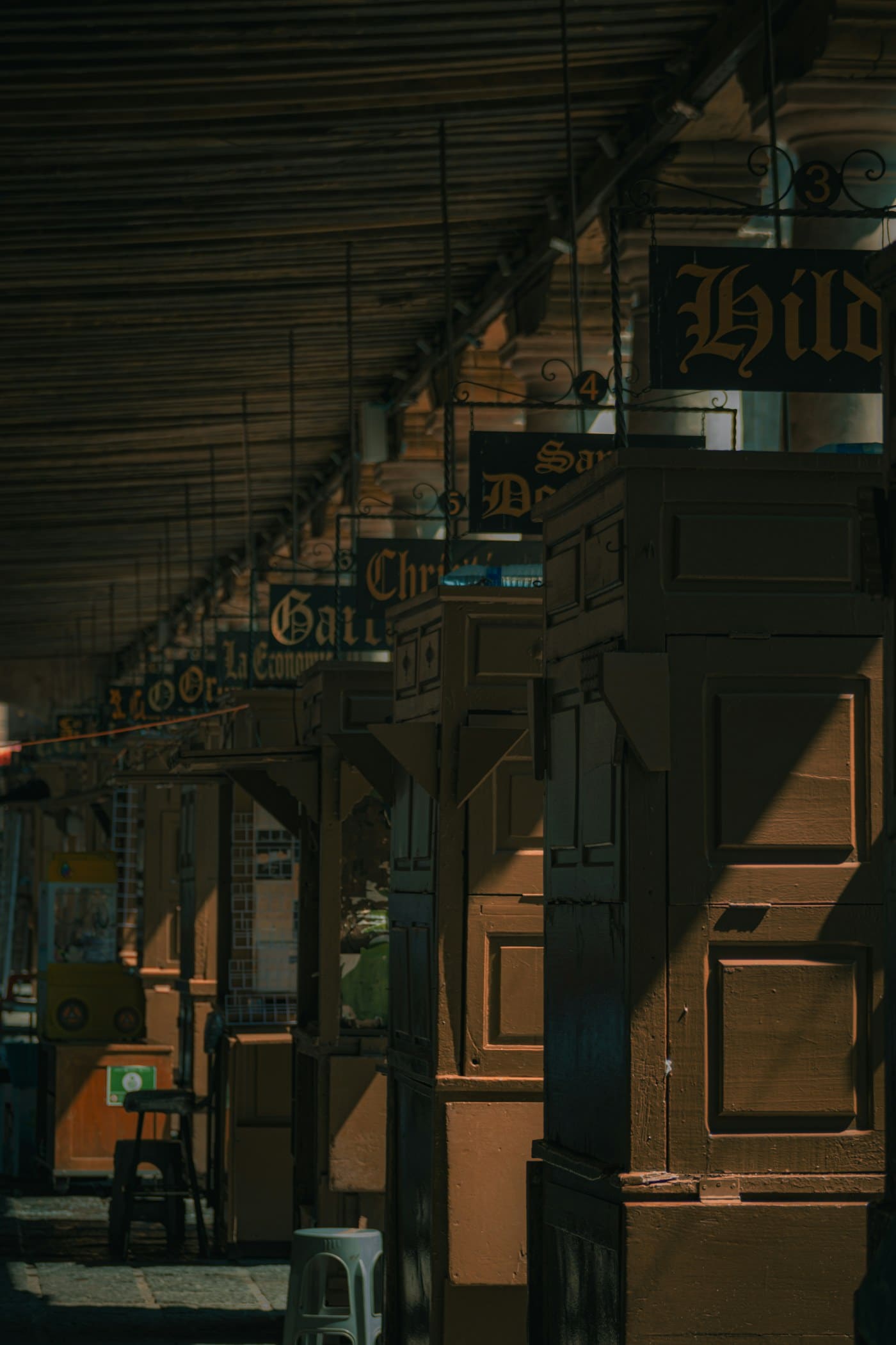 Market stalls in Centro Historico, Mexico City, with hanging signs and afternoon light.