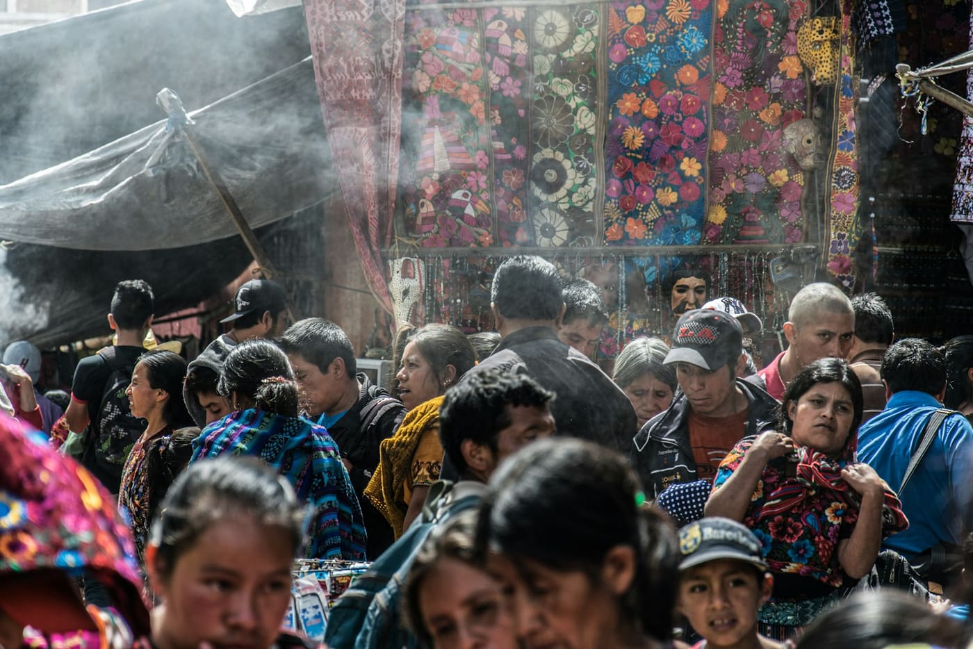 A crowded market aisle with colorful goods on display.