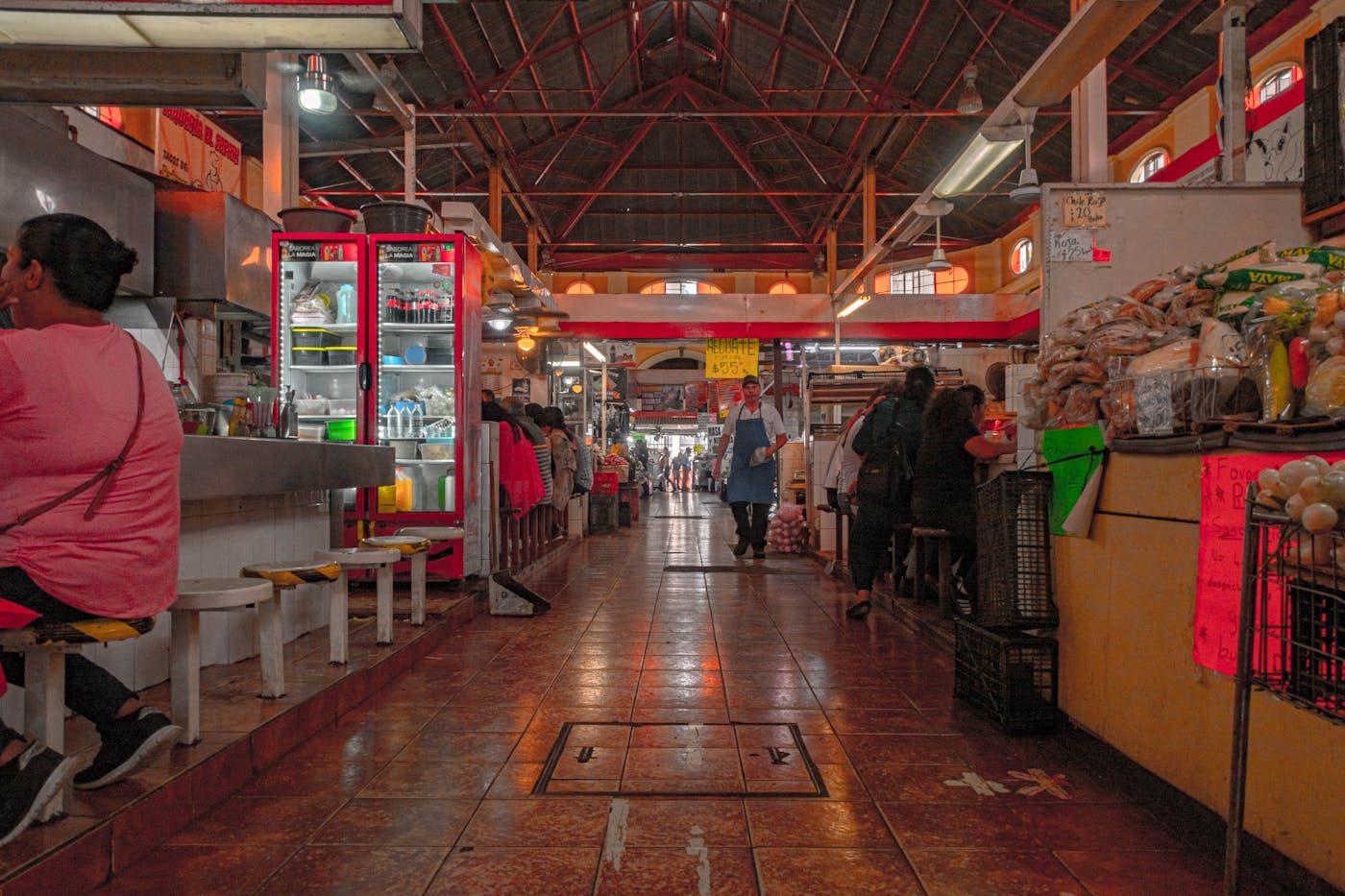 People shopping and eating inside a busy food market in Mexico City.