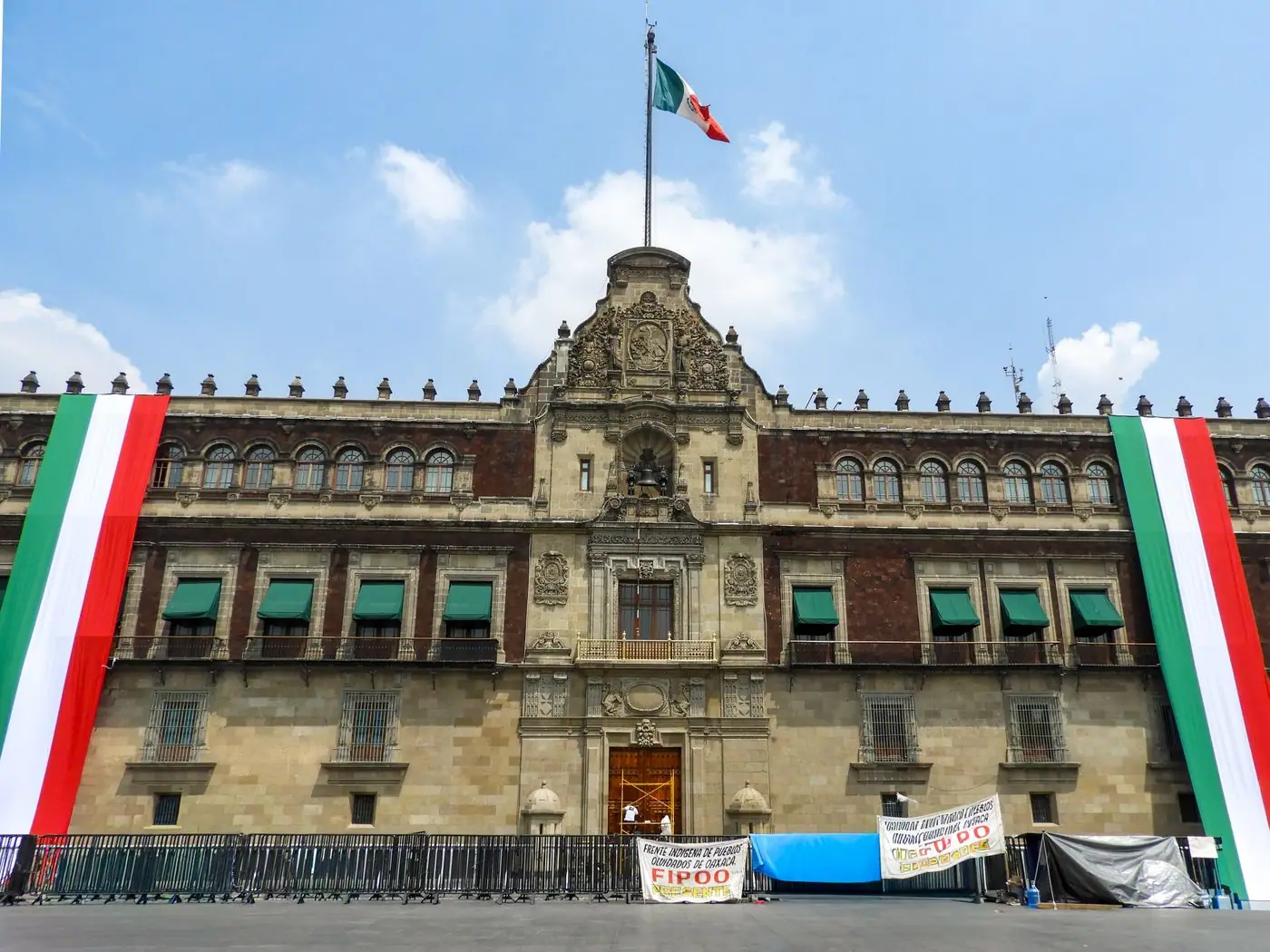 A Mexico City street decorated with green, white, and red flags and lights for September.