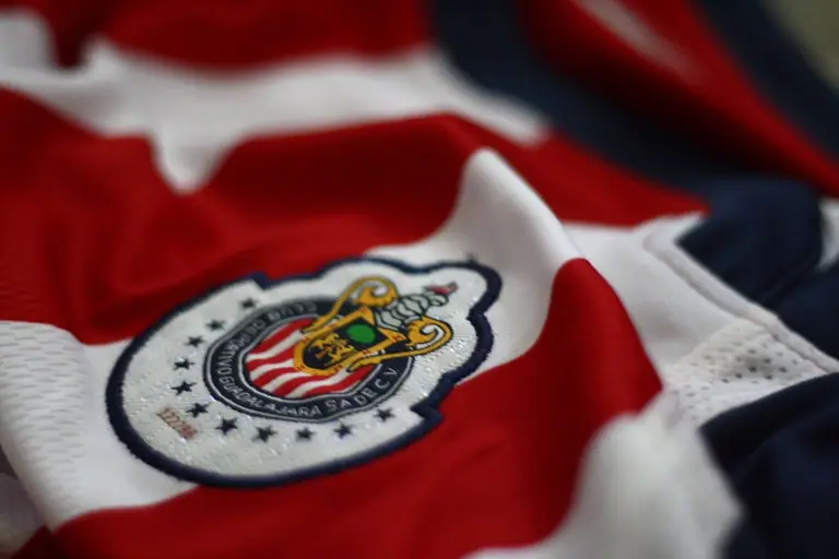 Close-up of the Chivas de Guadalajara crest on a red and white shirt