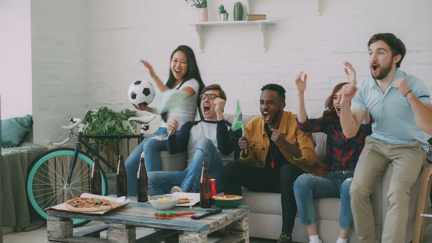 Friends hugging and laughing together after the final whistle of a soccer match.
