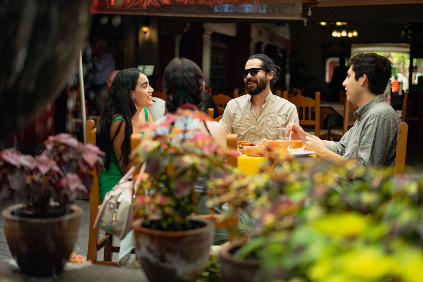 Friends eating and talking at a lively Mexican restaurant table.