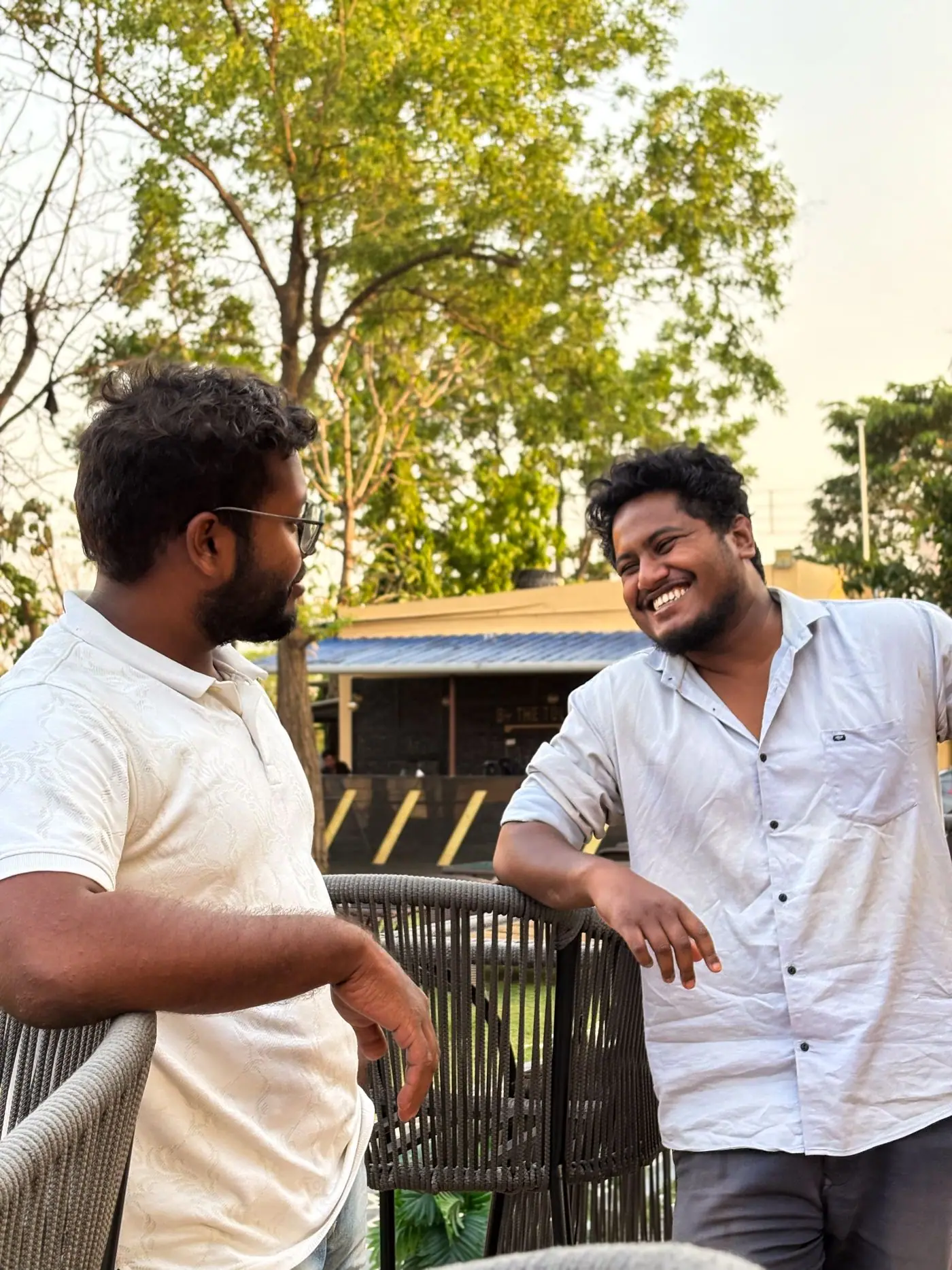 Two friends smiling during a relaxed conversation outdoors.