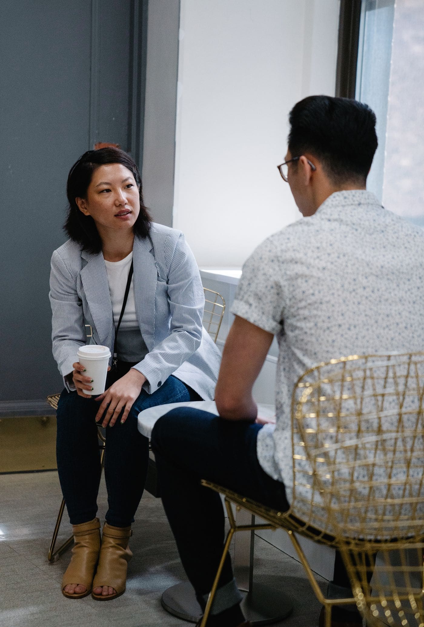 Two people talking over coffee in a modern cafe.