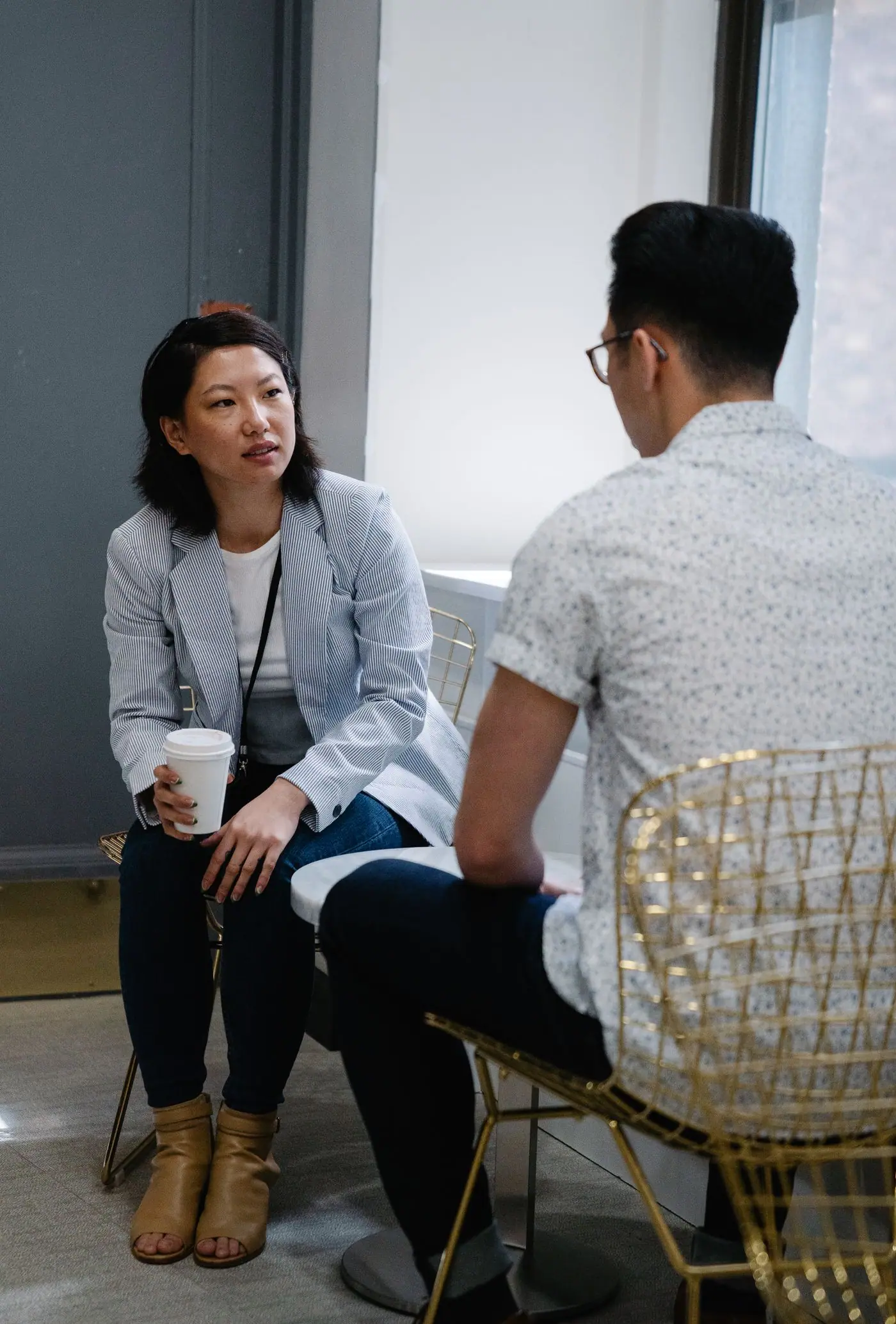 Two people talking over coffee in a modern cafe.