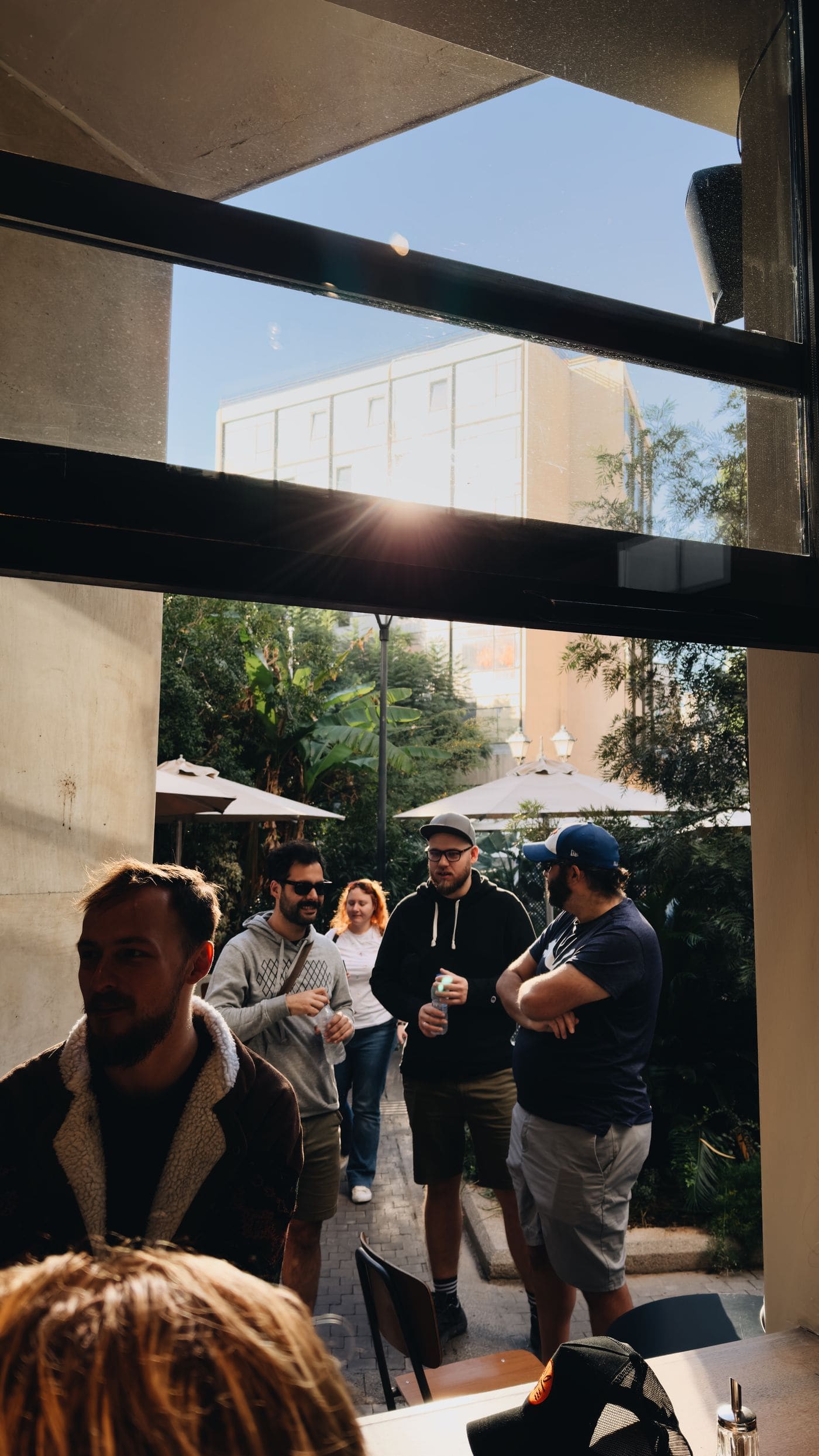 A group of adults talking at an outdoor cafe.