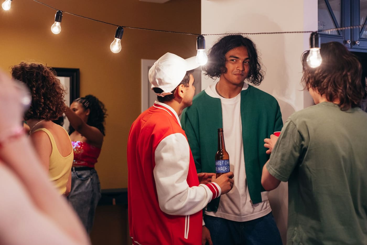 Adults talking in small groups at a lively indoor gathering.