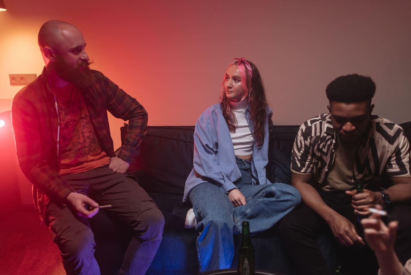 A group of friends sharing a final conversation on a sofa at night.