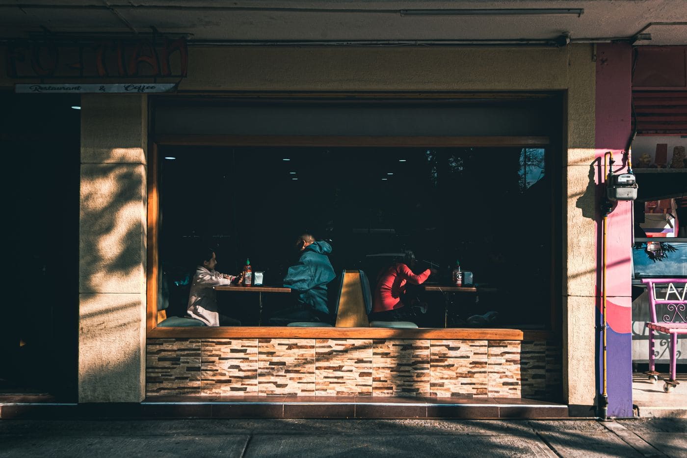 People talking inside a cafe in Mexico City, seen through the front window.