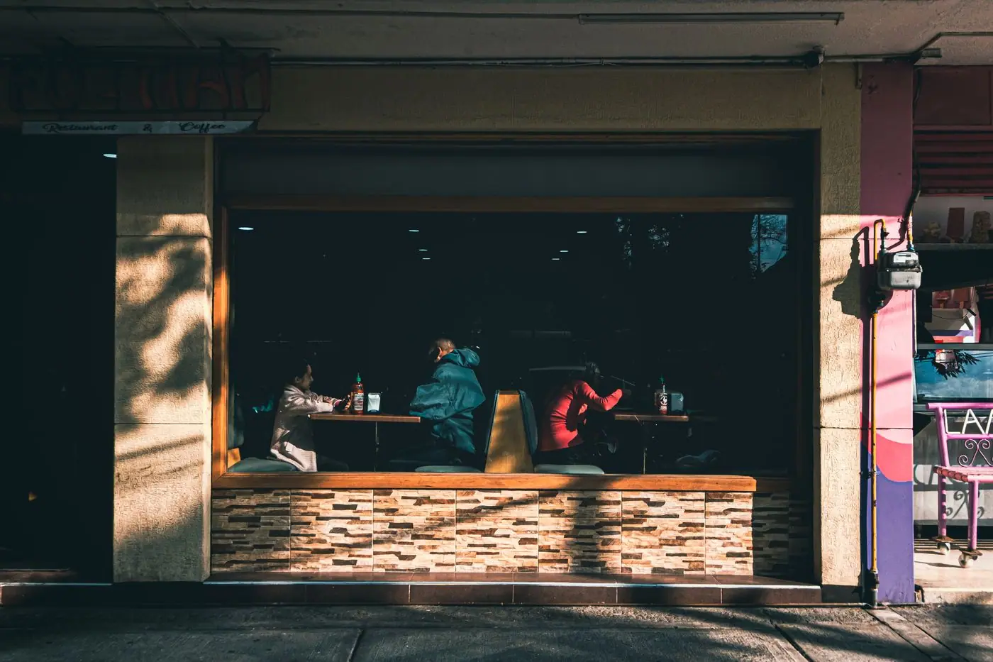 People talking inside a cafe in Mexico City, seen through the front window.