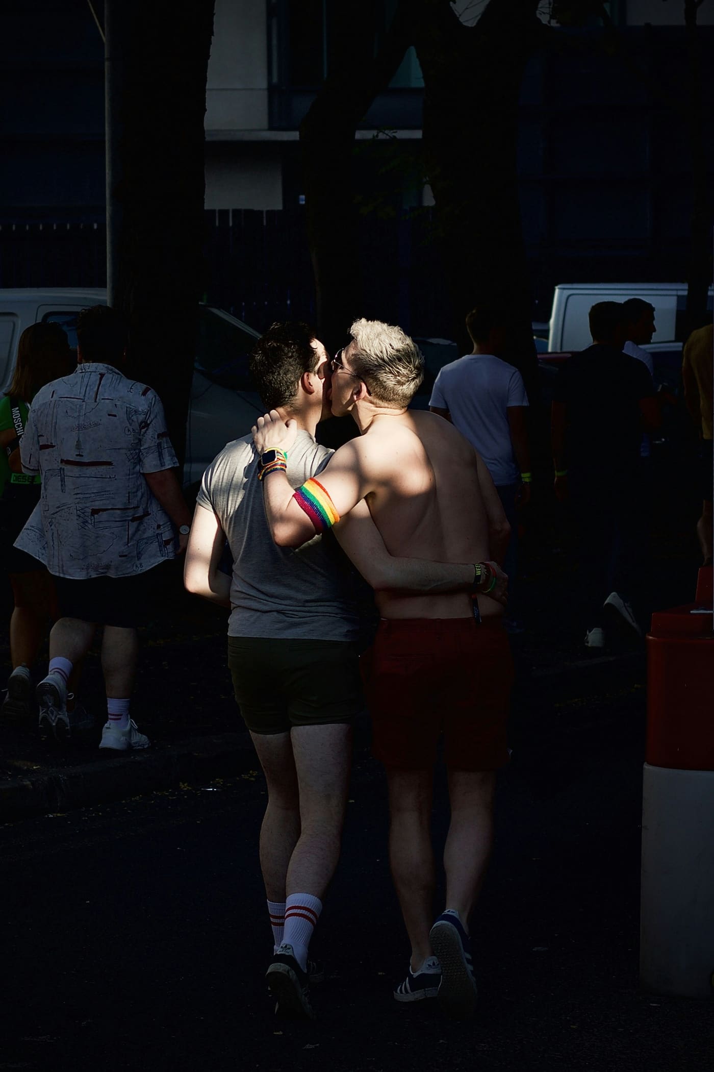 Two people in green outfits celebrating at a Pride street party.