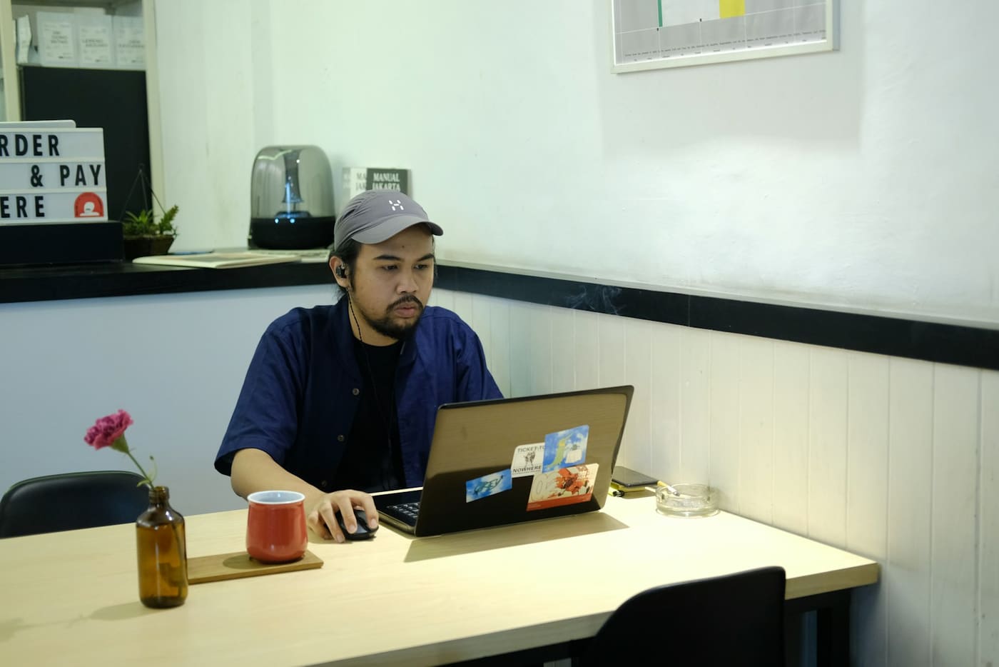 A person working on a laptop at a café table.