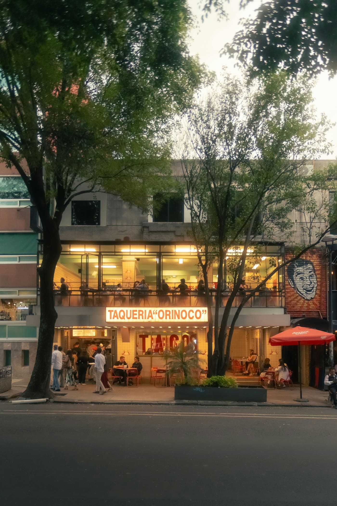 People eating outside Taqueria Orinoco in Mexico City in the evening.