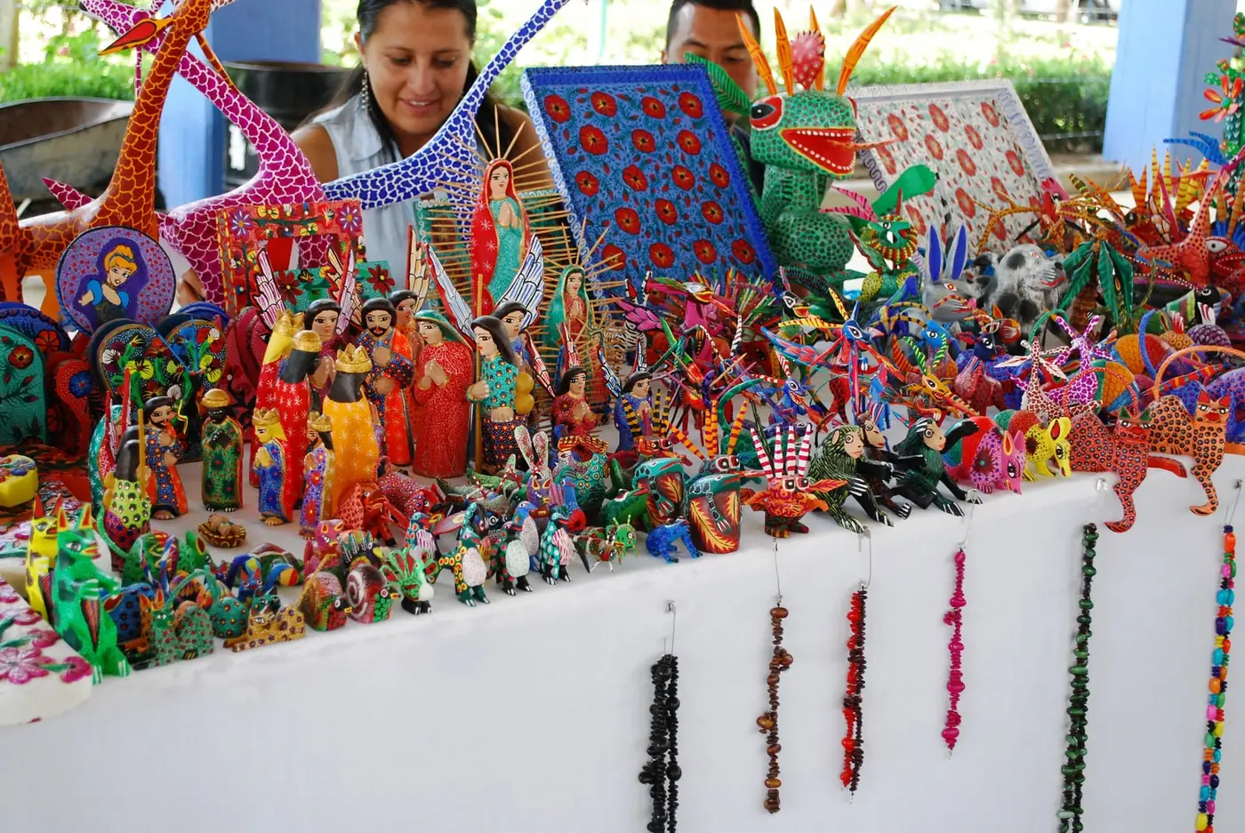 A stall in Oaxaca displaying rows of brightly painted wooden alebrijes