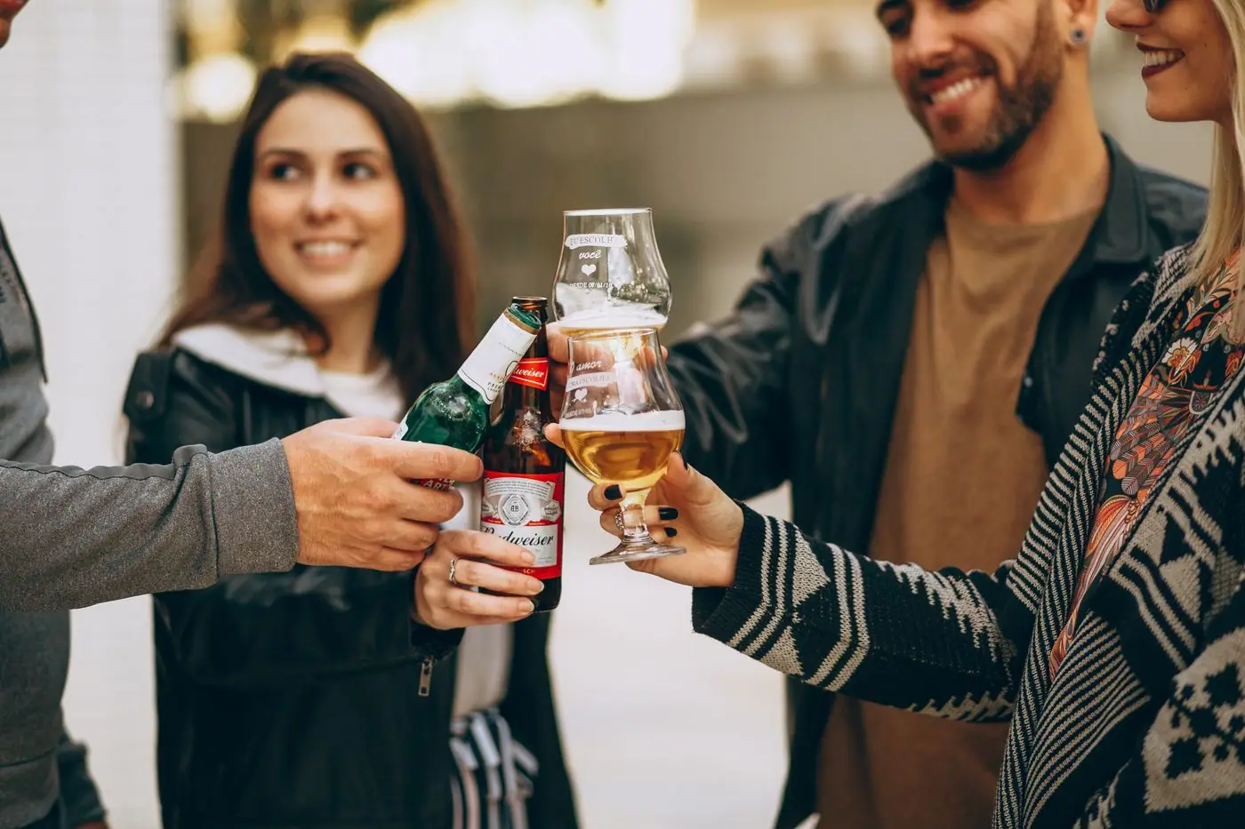 Friends toasting with beers and smiling together after a match, drinks raised.