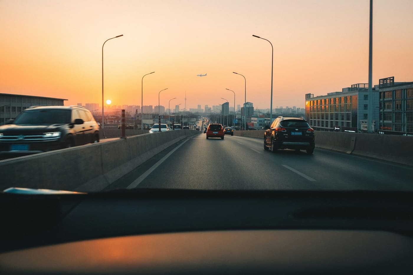 Cars queued along a road at sunset.