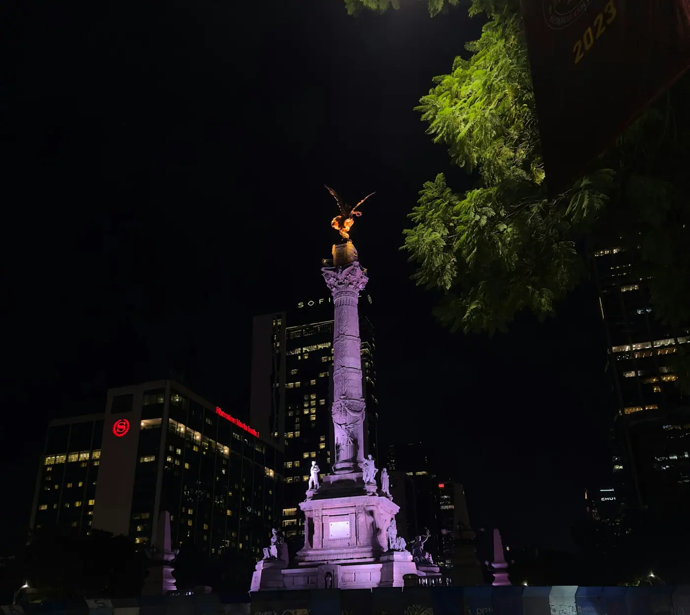 The Ángel de la Independencia monument lit up at night above Paseo de la Reforma.