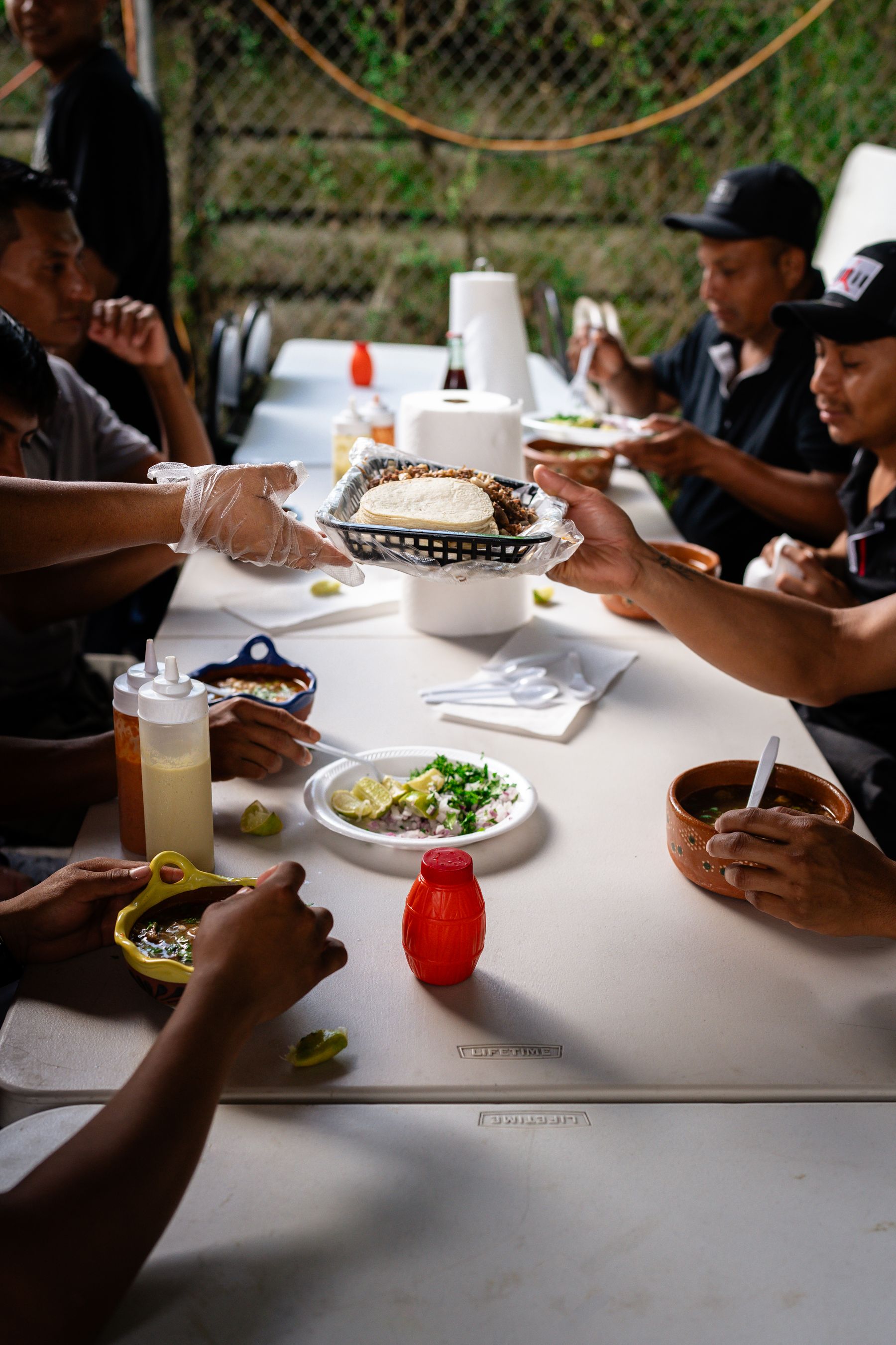 People sharing tacos around a table.
