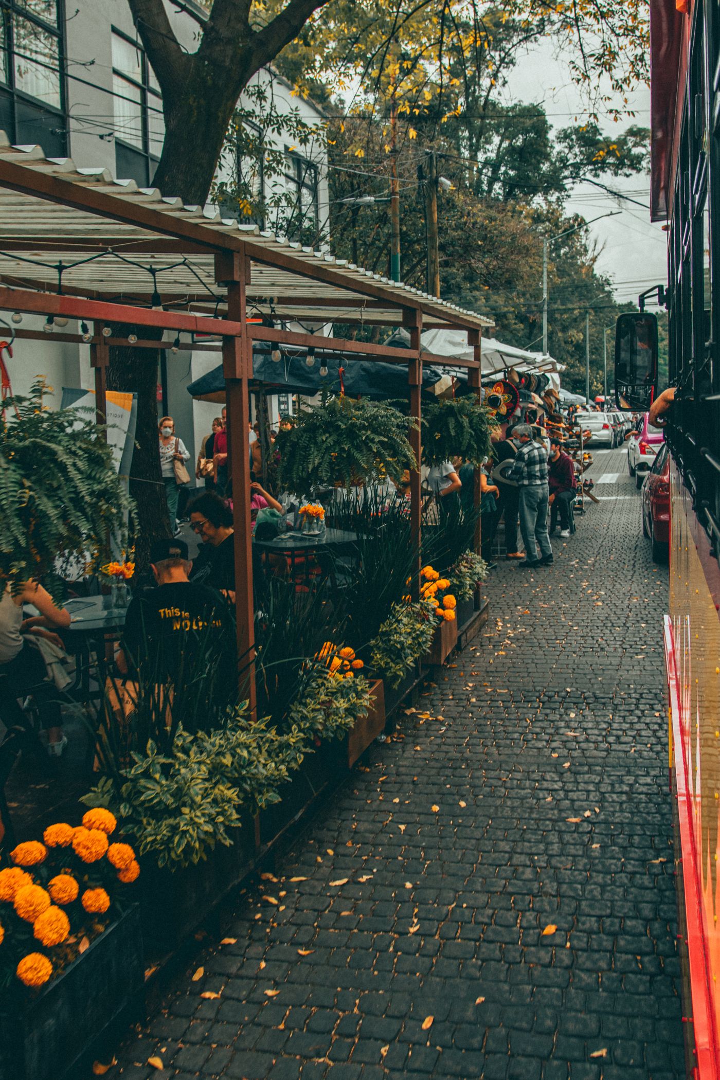 People socializing beside a lively sidewalk cafe in Mexico City.
