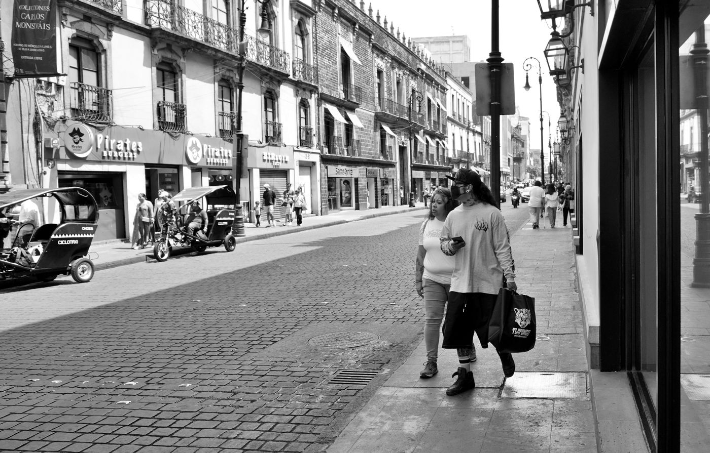 Pedestrians and street vendors in the historic center of Mexico City.
