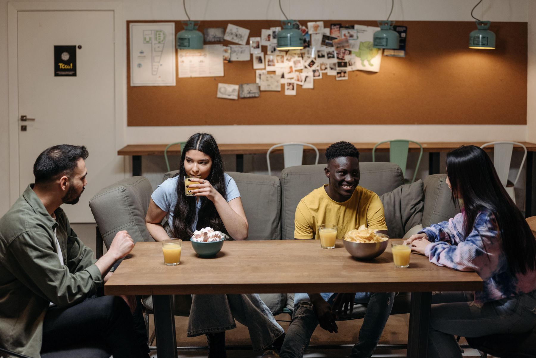 A group of friends talking and laughing on a couch.