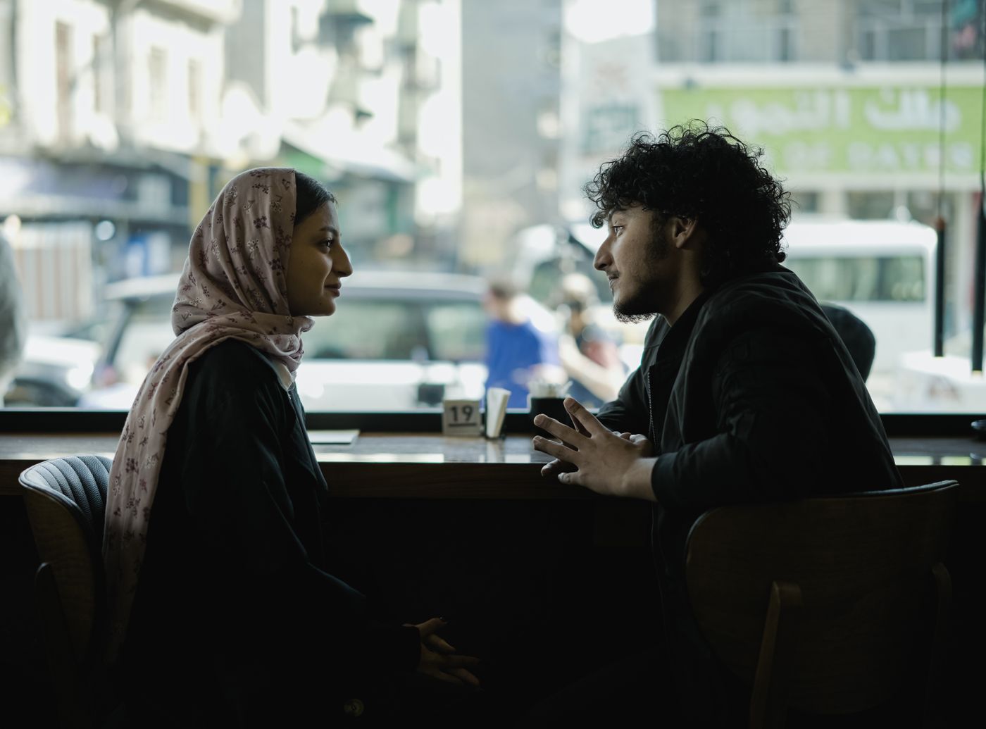 Two people talking calmly at a cafe table.