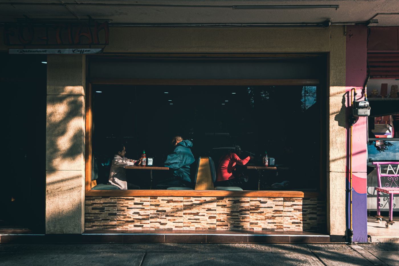 People talking inside a cafe in Mexico City, seen through the front window.