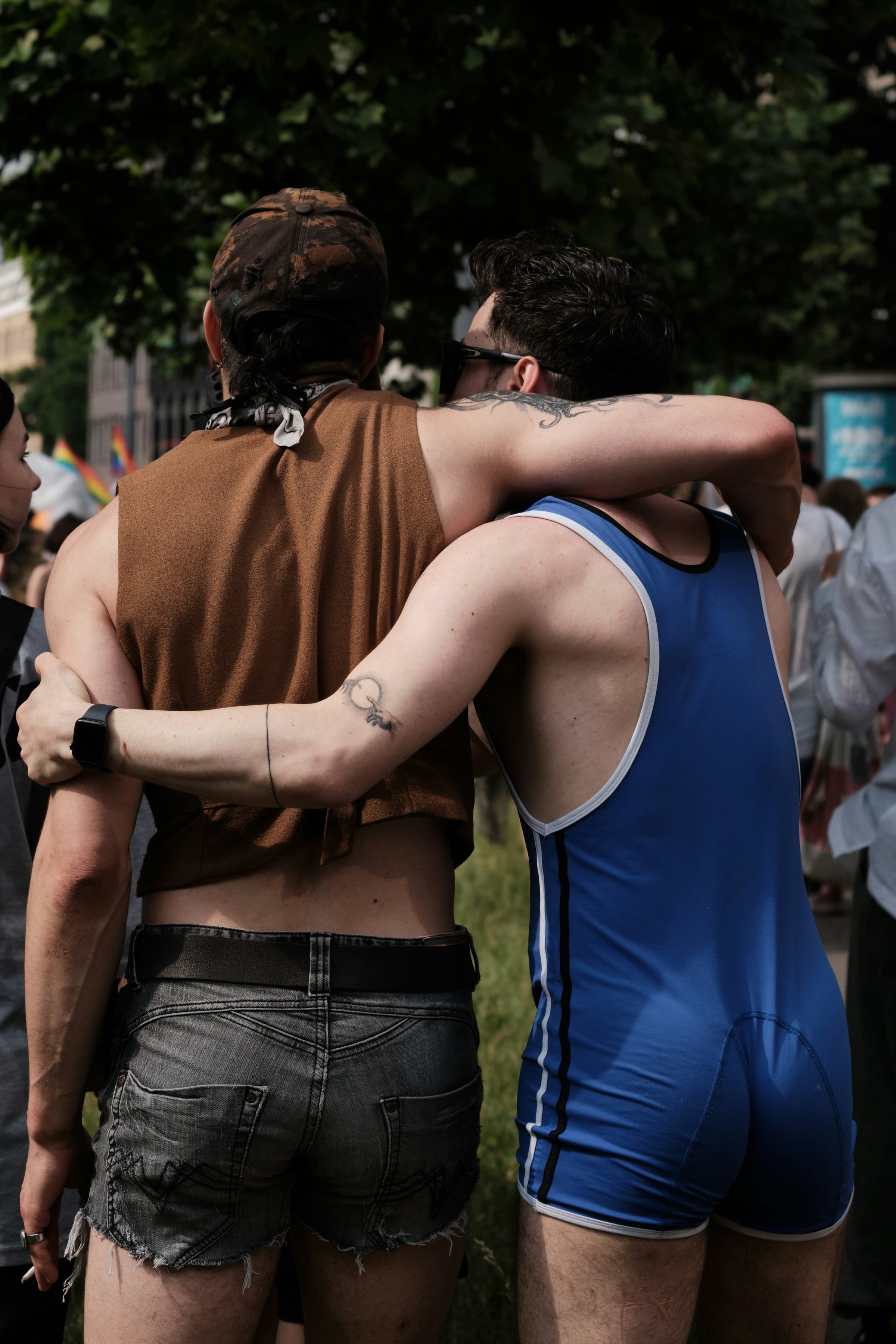 Two men standing close together at a Pride parade.