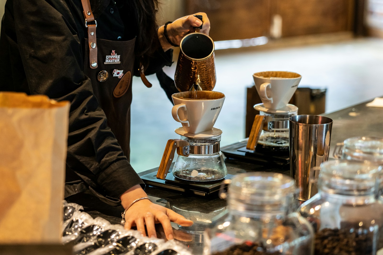 A barista pouring water over a filter coffee.