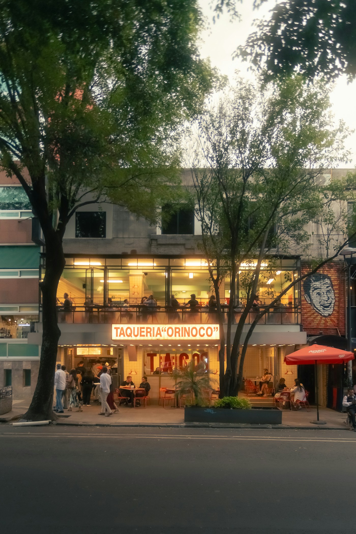 People eating outside Taqueria Orinoco in Mexico City in the evening.