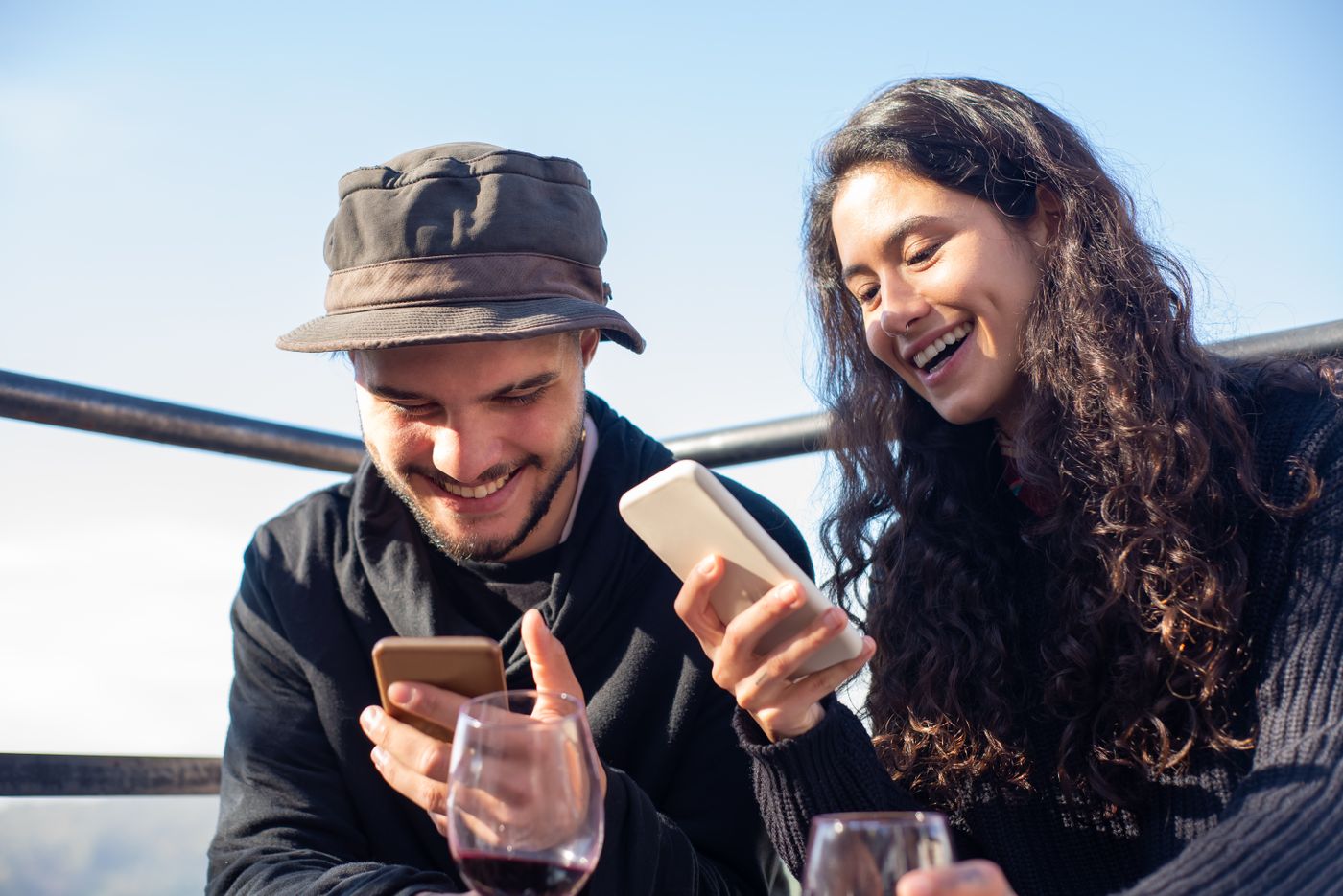 Friends crowding around a phone organizing a get-together with drinks on the table.