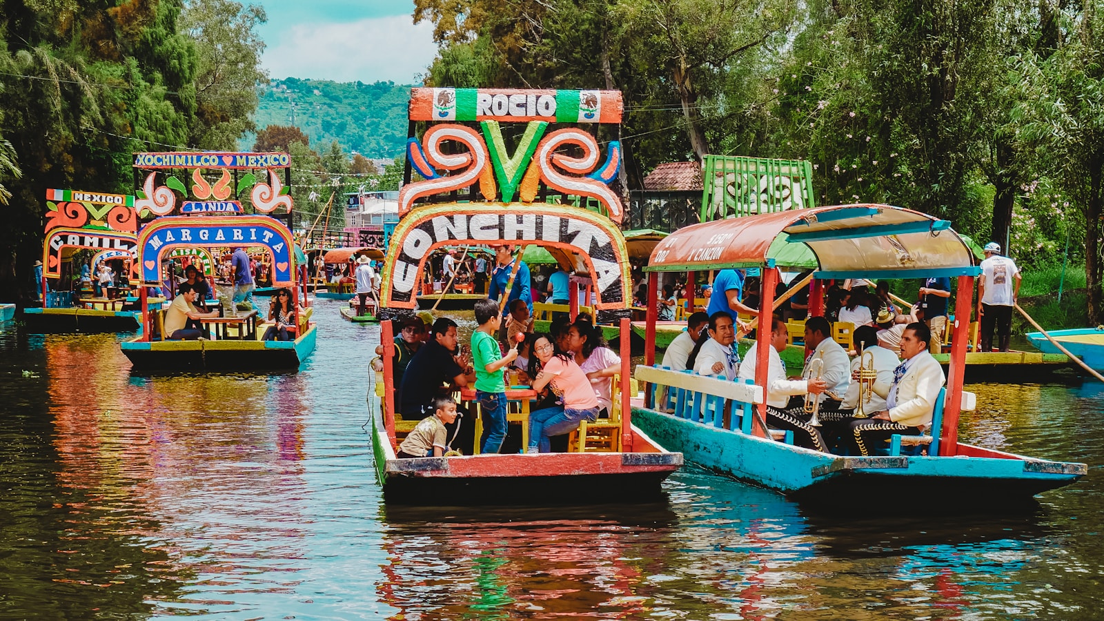 People riding brightly painted trajinera boats on the Xochimilco canals.