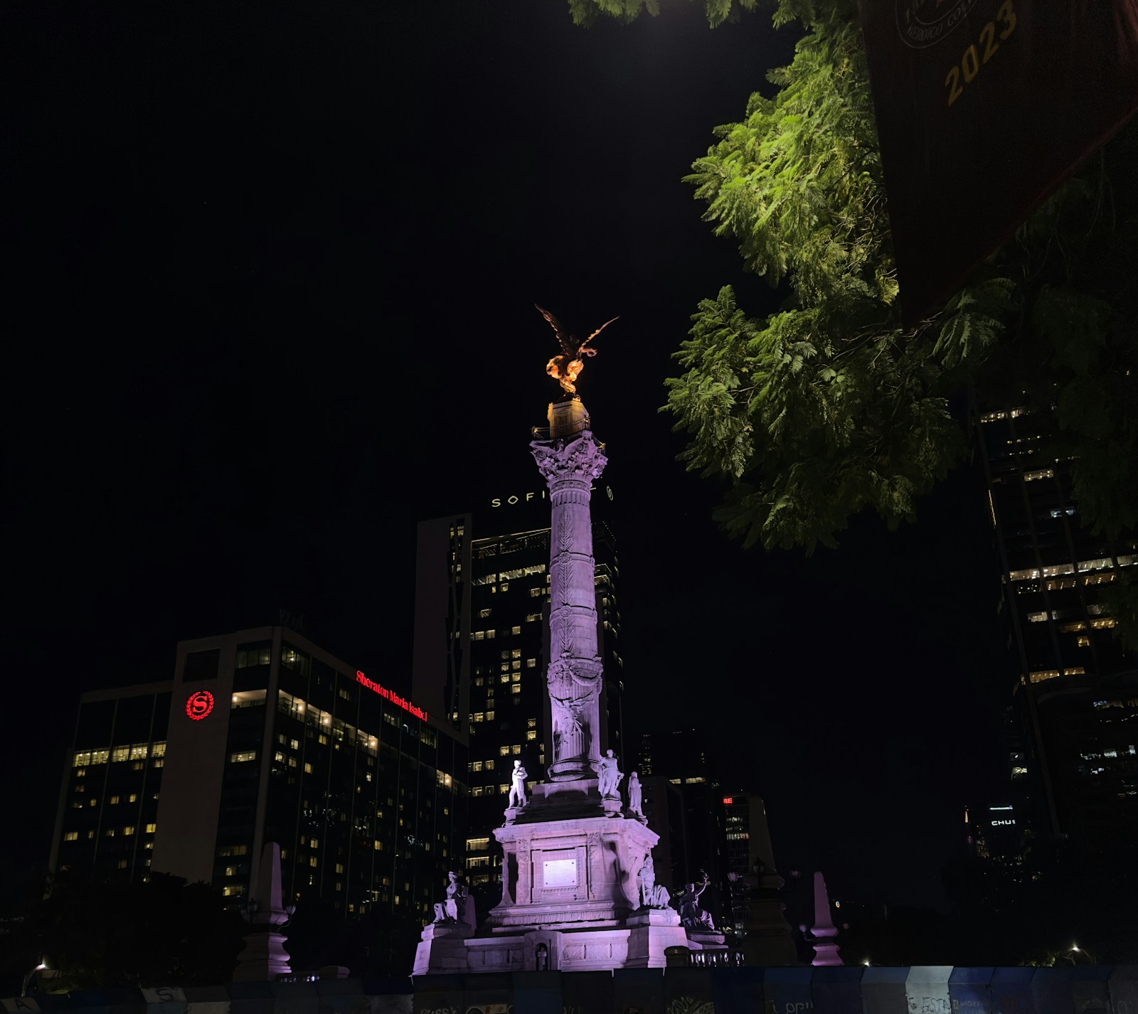 The Ángel de la Independencia monument lit up at night above Paseo de la Reforma.